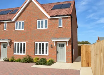 A Modern Red-Brick House With White-Framed Windows And Solar Panels Stands Before A Clear Blue Sky