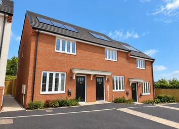 A Red Brick Semi-Detached House With Solar Panels On Its Roof Stands Before A Paved Driveway Under A
