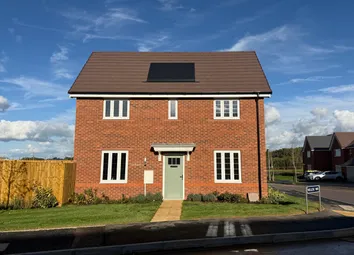 A Two-Story Red Brick House With Solar Panels Sits Behind A Green Lawn And Walkway