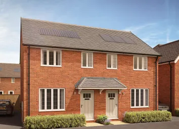 A Pair Of Modern Brick Semi-Detached Houses With Manicured Hedges In The Foreground Stand Against A