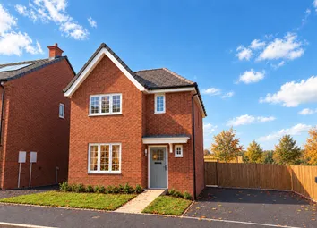 A Modern Red-Brick House With A Grey Front Door And Small Green Lawns Stands Under A Bright Blue Sky