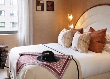 Double Bed With Circular Headboard, Bedside Tables, End Table And Seating.