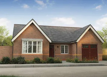 A Two-Story Brick House With A Gabled Roof, Surrounded By A Fence And Greenery