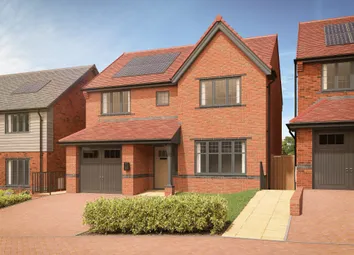 A Modern Brick House With Solar Panels On The Roof Sits Behind A Neatly Trimmed Hedge