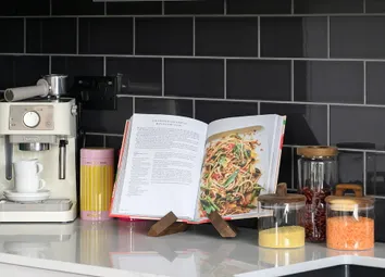 Closeup Of Kitchen Counter With Black Polished Splashback Tiles, White Countertops, Chrome Black