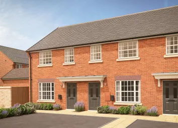 A Row Of Modern Brick Townhouses With Manicured Gardens In The Foreground Stands Against A Clear Blu