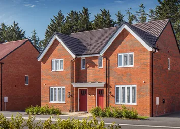 A Pair Of Modern Brick Semi-Detached Houses With Red Doors And White-Framed Windows Stand In The For