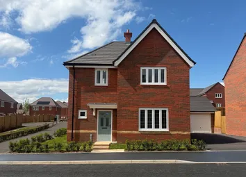 A Row Of Modern Brick Houses With Manicured Lawns And Paved Driveways Sits Under A Clear Blue Sky.
