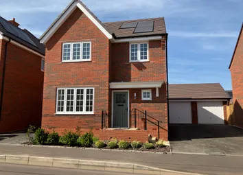 A Modern Red Brick House With White-Framed Windows And Solar Panels On The Roof Stands In The Foregr