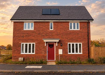 A Two-Story Red Brick House With A Red Front Door Stands Before A Soft Sunset Sky With Scattered Clo