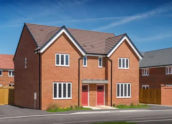 A Modern Brick Semi-Detached House With Red Doors Stands In The Foreground