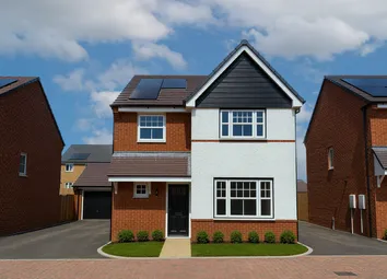 A Modern Two-Story House With White And Brick Facade And Solar Panels On The Roof Stands On A Paved