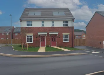 A Newly Built Semi-Detached House With Red Doors And White Windows Stands On A Paved Road In The For
