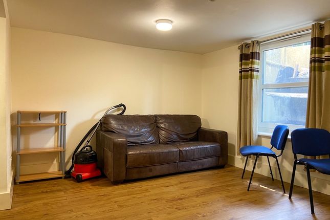 A Cozy Living Room With A Brown Sofa, Two Blue Cha...