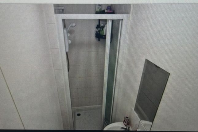 A Compact And Functional Bathroom Featuring A Show...