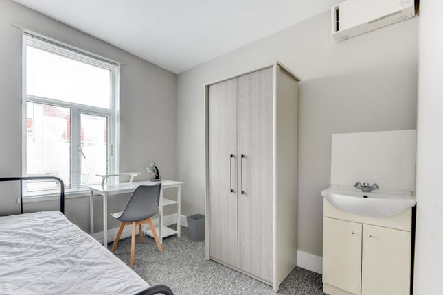 A Bright, Tidy Bedroom Featuring A Bed, A Wardrobe...