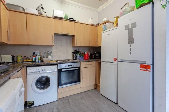 A Compact Kitchen Featuring Modern Appliances Incl...