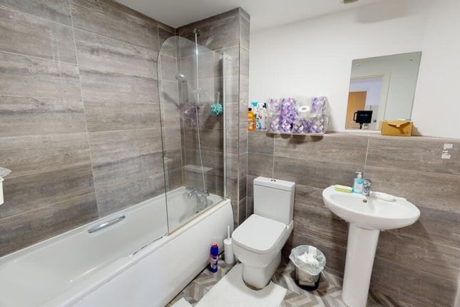 A Modern Bathroom Featuring Sleek Grey Tiles, A Sp...