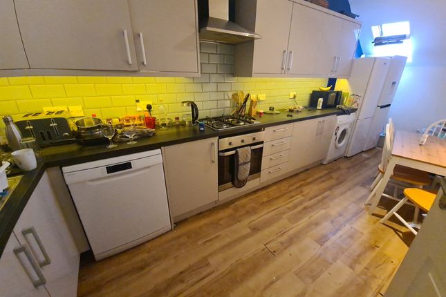 A Modern Kitchen Featuring A Long Black Countertop...