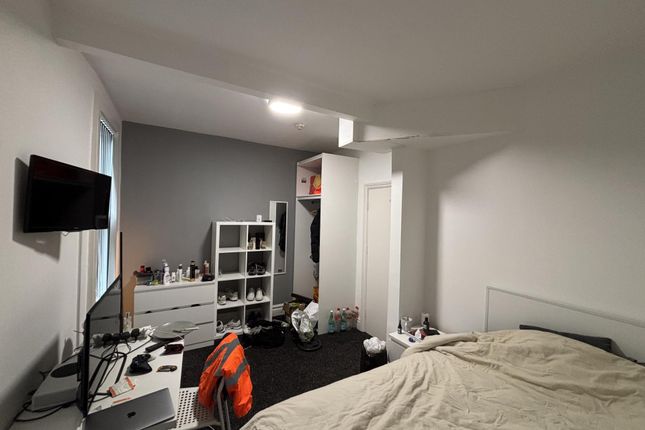 A Cozy Bedroom Featuring A Neatly Made Bed, A Smal...