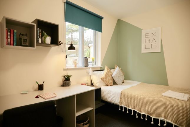 A Cozy Single Bedroom Featuring A Window With A vi...