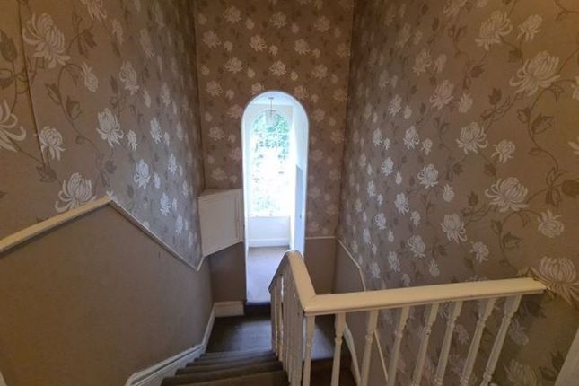 A Quaint Hallway With Floral Wallpaper And A White...