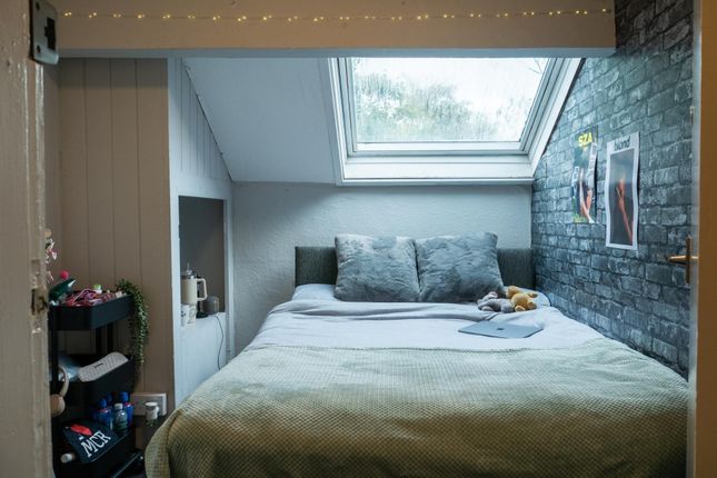 A Cozy Bedroom Featuring A Double Bed Under A Slop...