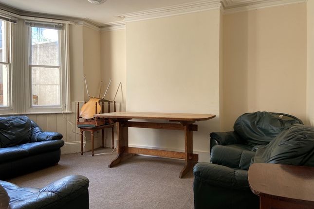 A Spacious And Well-Lit Living Room Featuring Comf...