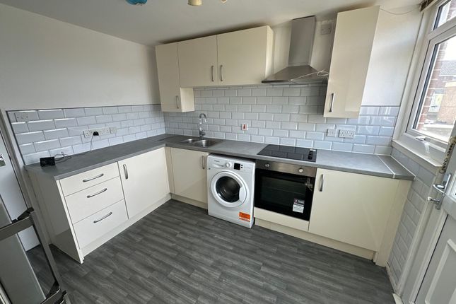 A Modern Kitchen Featuring Sleek Cream Cabinets, A...
