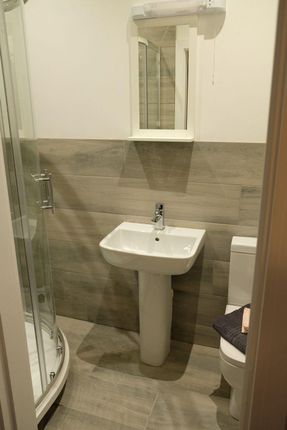 A Modern Bathroom Featuring A Corner Shower Enclos...