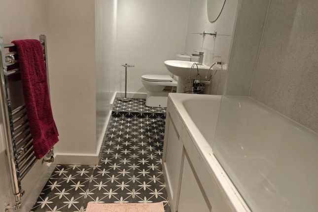 A Stylish Bathroom Featuring A Modern Bathtub, Whi...