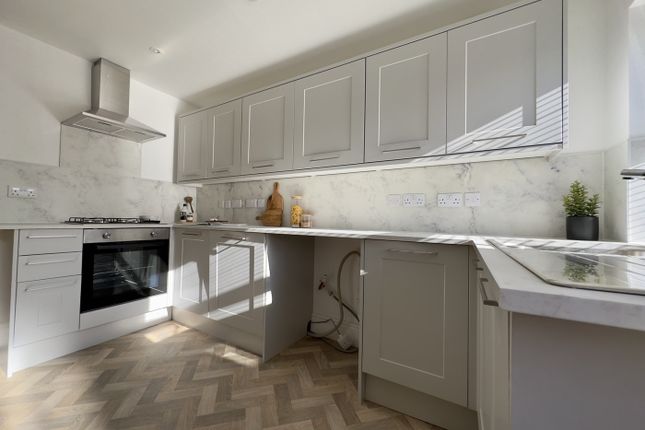A Stylish And Modern Kitchen Featuring Ample Stora...
