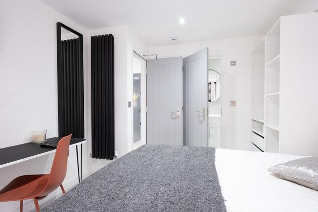 A Modern, Well-Lit Bedroom Featuring A Comfortable...