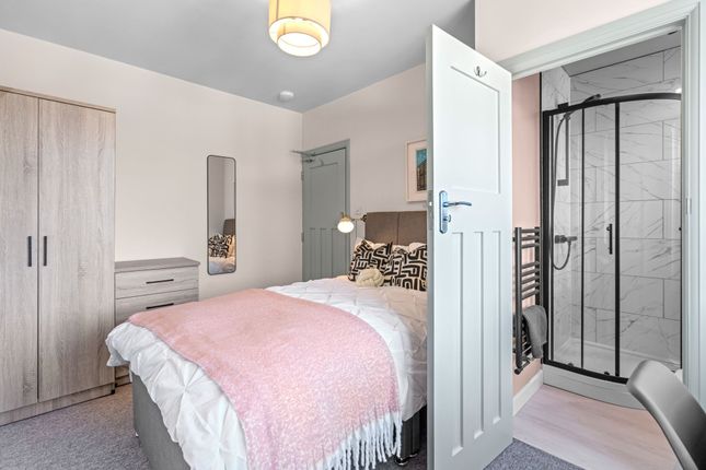 A Bright And Cozy Master Bedroom Featuring A Comfo...