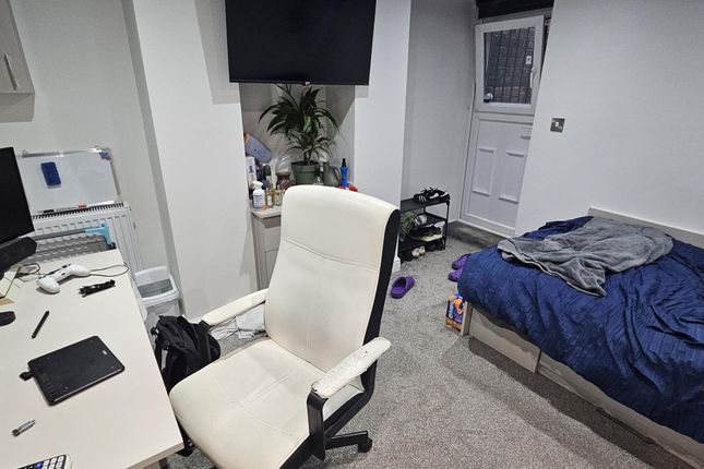 A Cozy Bedroom Featuring A Single Bed With Some cl...