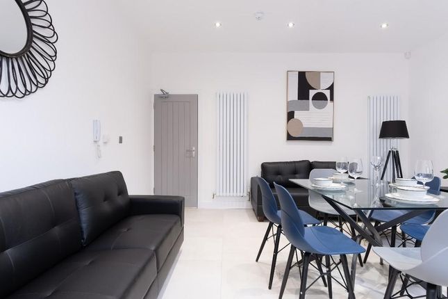 A Modern And Spacious Living Room With A Black Sof...