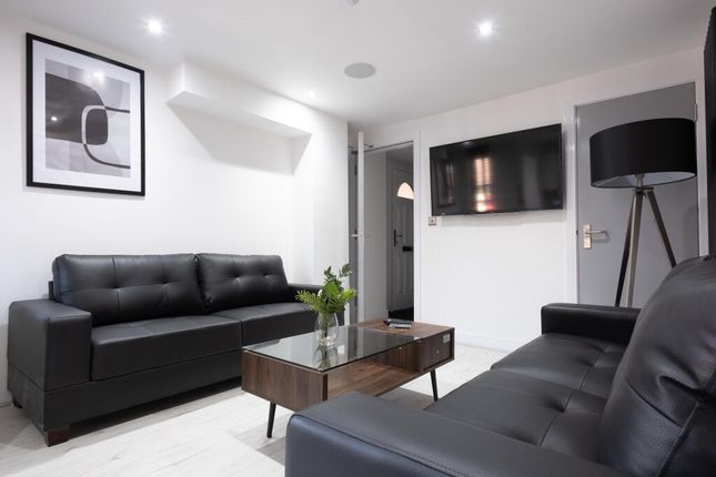 A Modern Living Room Featuring Sleek Black Leather...