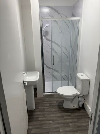 A Modern And Clean Bathroom Featuring A Glass-Encl...