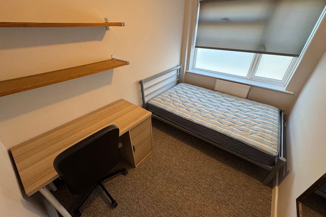 A Tidy Single Bedroom Featuring A Metal-Frame Bed ...