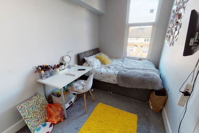 A Cozy Single Bedroom Featuring A Bed, A Bedside T...