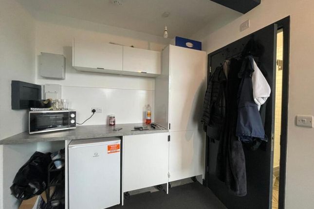 A Compact Kitchen Area Featuring White Cabinetry, ...