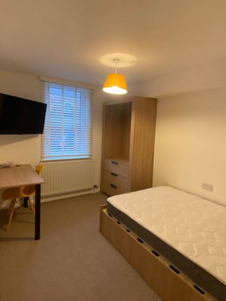 A Cozy Bedroom Featuring A Comfortable Single Bed,...
