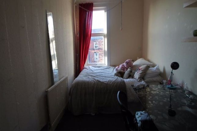 A Cozy Bedroom Featuring A Neatly Made Bed, A Wind...