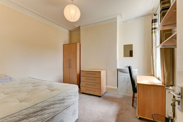 A Well-Lit Bedroom Featuring A Bed And A Simple Wo...