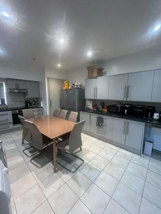 A Modern Kitchen With Ample White Cabinetry, A Din...