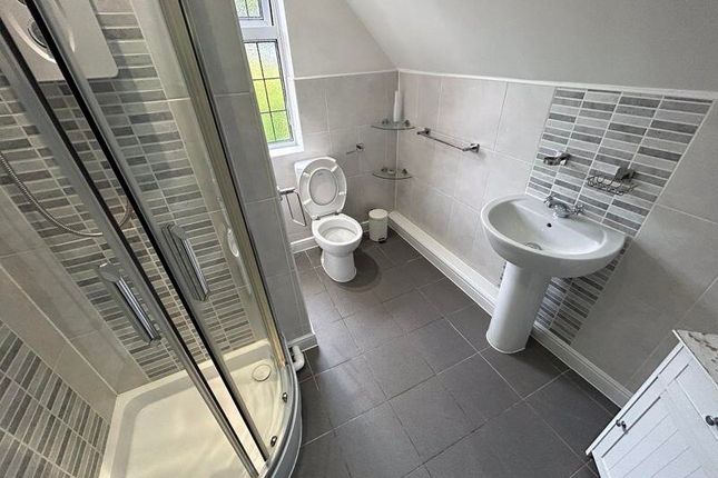 A Bright And Clean Bathroom Featuring A Shower Enc...