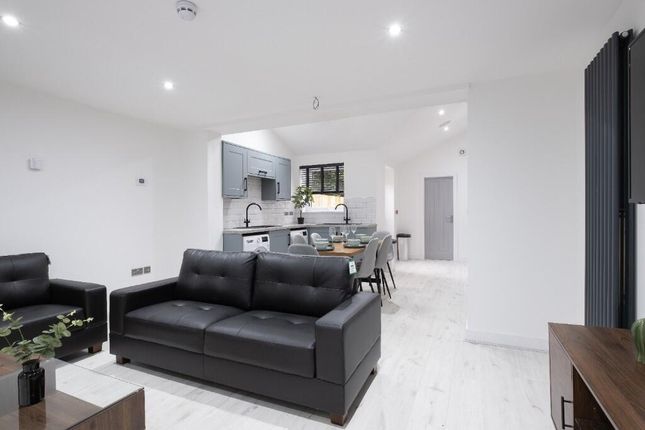 A Modern, Bright Living Room With Sleek Black Sofa...