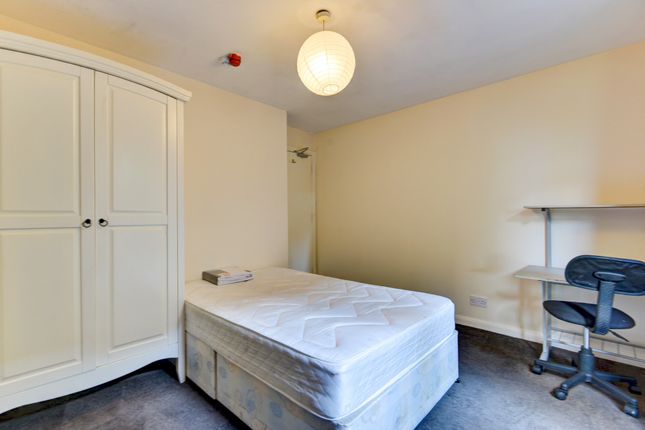 A Tidy And Well-Lit Bedroom Featuring A Single Bed...