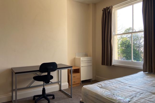 A Bright, Tidy Bedroom With A Large Window Providi...