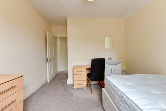 A Neat And Simple Bedroom Featuring A Large Bed, A...